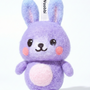 Front view of a handmade Woobbi bunny keychain, crafted from purple bubbly wool felt. It has small yellow ears, rosy pink cheeks, and a smiling face with black eyes and nose. A small tag with the brand name 'Woobbi' is attached to the top. It is set against a plain white background.