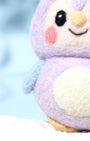Close-up detail of purple needle-felted owl charm showing the fuzzy natural wool texture, pink blushed cheeks, and heart-shaped face design.